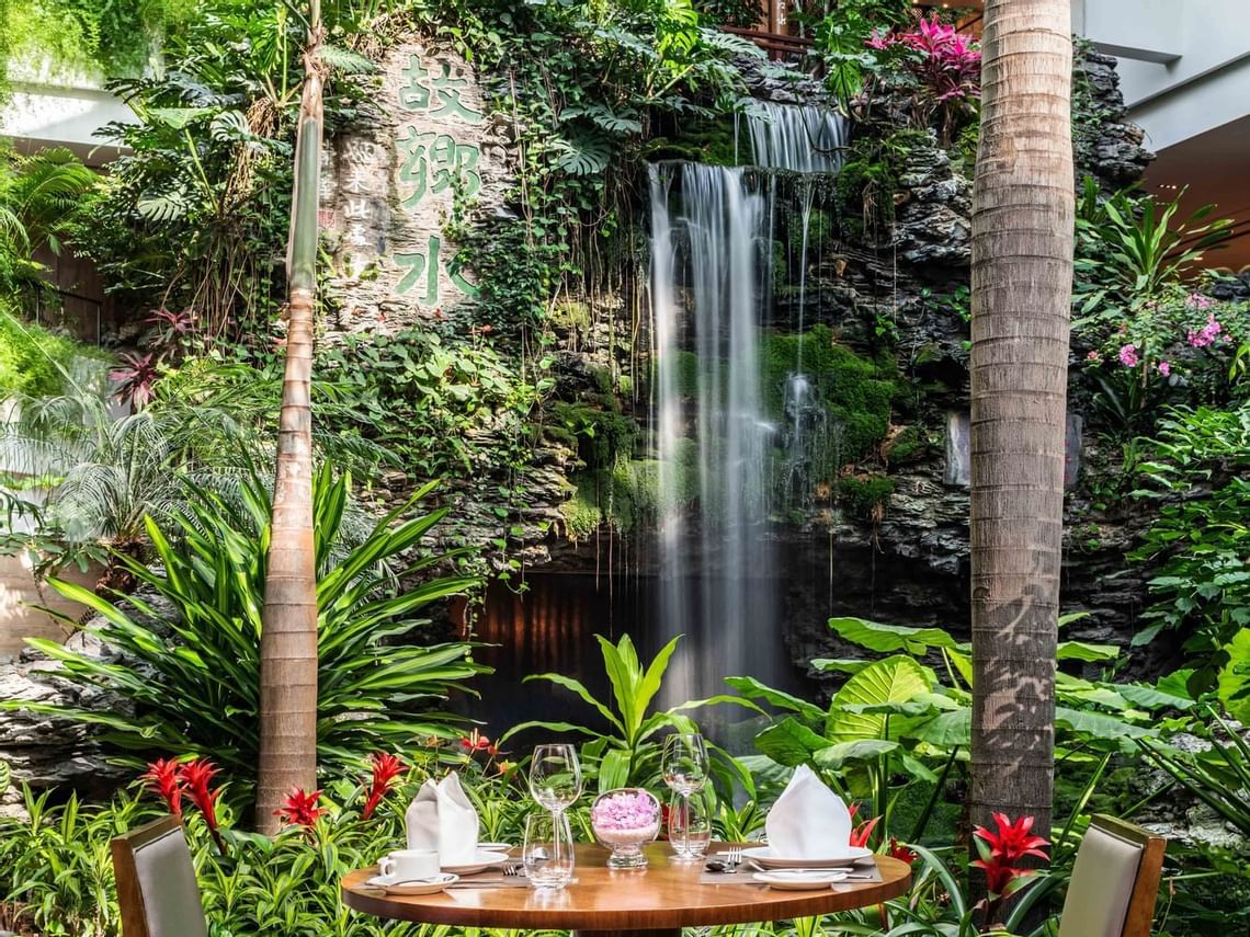 Project photograph of a heritage-scale hotel atrium and waterfall.